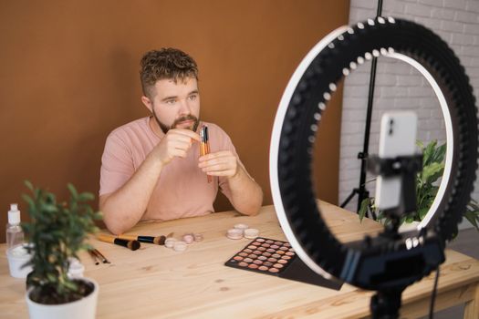 Bearded man professional beauty make up artist vlogger or blogger recording makeup tutorial to share on website or social media.