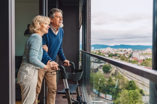 Elderly married couple out in the balcony looking at the view of the city