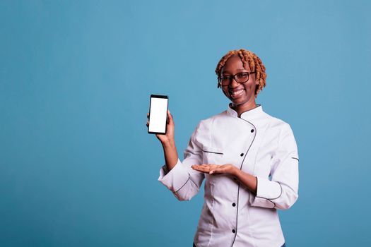 Cook holds cell phone with empty screen for advertising