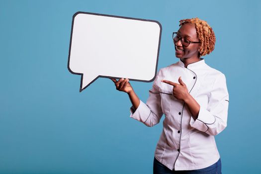 Female cook pointing to empty white dialogue bubble