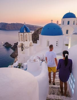 Couple walking at the Greek village of Oia Santorini Greece, men and women on vacation in Greece