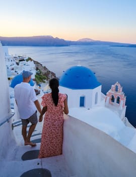 Couple walking at the Greek village of Oia Santorini Greece, men and women on vacation in Greece