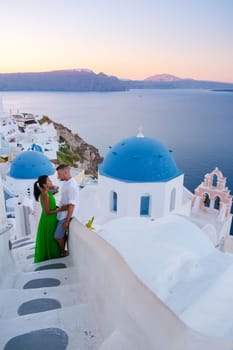 Couple hugging and kissing on a romantic vacation in Santorini Greece, men and women visit Santorini