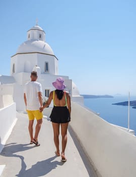 Couple visit Fira capital of Santorini island and the view of volcanic caldera, Santorini, Greece