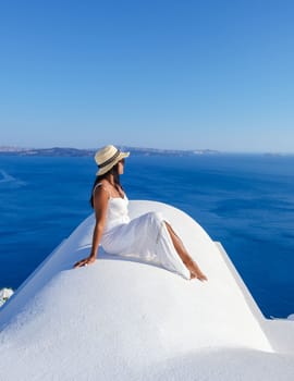Young Asian women on vacation in Santorini Greece, girl with hat at the Greek village in Santorini
