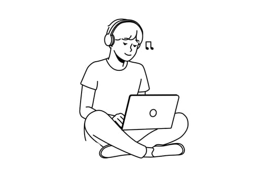 Guy sitting on grass with laptop and headphones