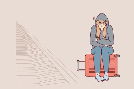 Tired woman sits on suitcase near railway waiting for train and freezes at station. Vector image