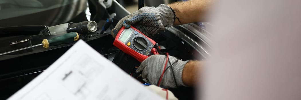 Mechanical service using multimeter to check voltage level in car battery and auto documentation diagram