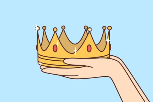 Person hands holding gold crown