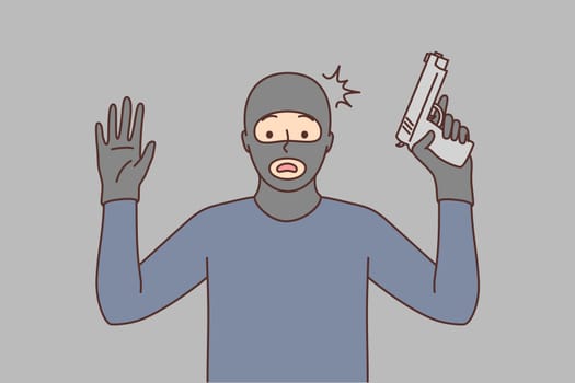 Male robber with gun raise hands up
