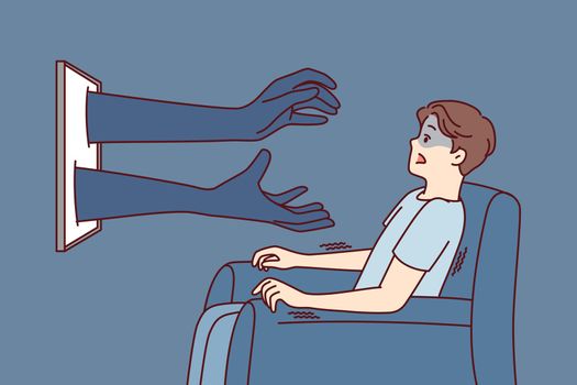Man sitting in chair in front of TV gets scared sees hands reaching out from display. Vector image