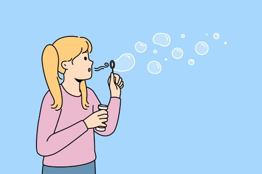 Happy girl blowing soap bubbles