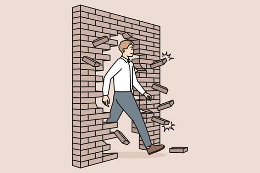 Motivated businessman break wall go for success