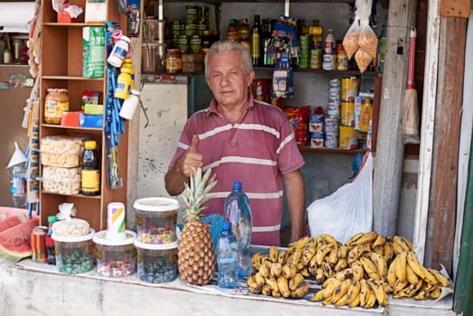 This is his livelihood. Portrait of a street vendor selling a variety of food at his stall.