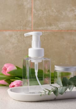 Transparent plastic container with a dispenser on the table. Bottle for liquid soap, shampoo