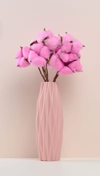 Pink ceramic vase with rose cotton bouquet on white table