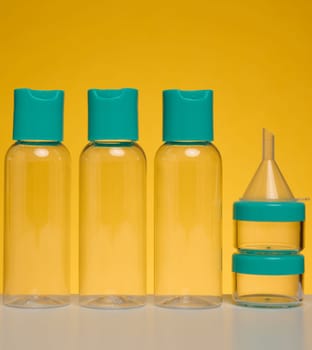 Transparent plastic bottles for liquid cosmetics on a yellow background