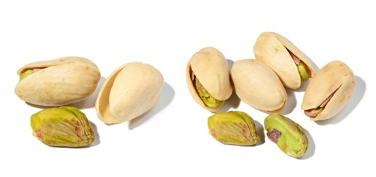 Salted open inshell pistachios isolated on a white background, tasty and healthy snack