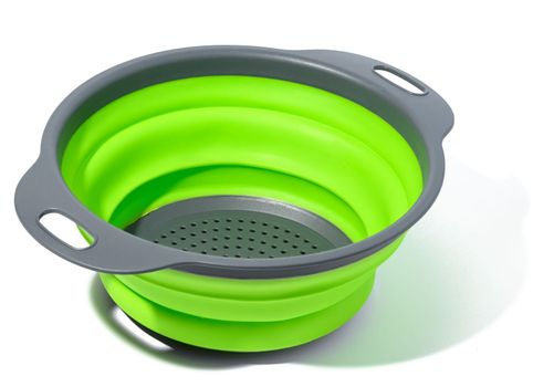 Plastic green collapsible colander on white isolated background