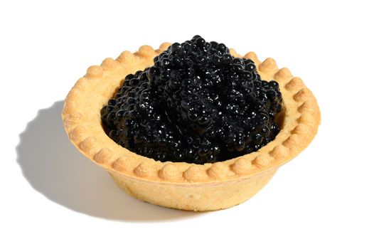Black caviar in a round tartlet on a white isolated background