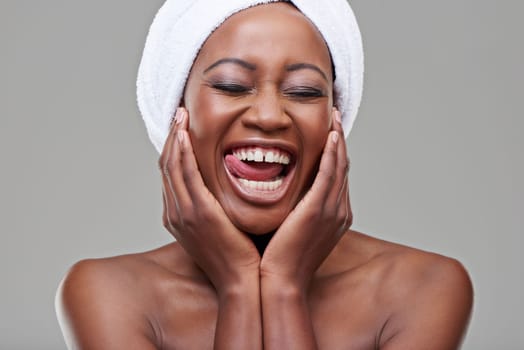 Her laughter is infectious. Studio shot of a young woman with beautiful skin being cheerful.