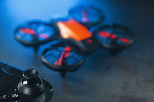 A reconnaissance quadcopter drone with an orange body a
