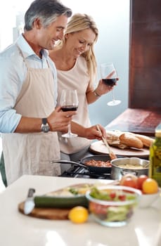 Wow Youre cooking up a storm. an affectionate mature couple drinking wine while cooking dinner in their kitchen at home.