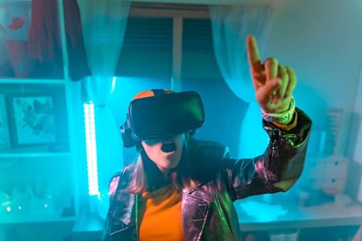Wireless technologies. Young woman using virtual reality glasses in the dark room with neon lighting