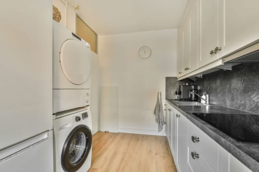 a white kitchen with a washing machine and a sink