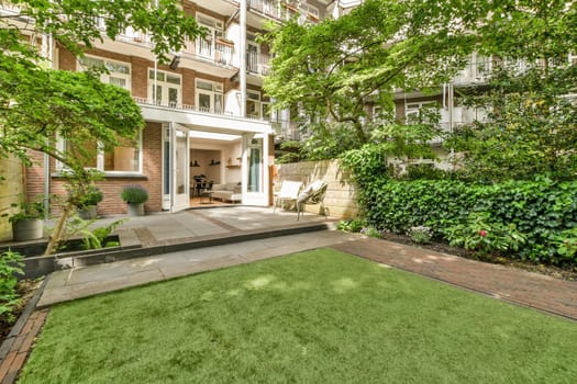 the backyard of an apartment building with a green lawn