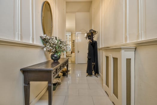 a hallway with a table and a coat rack and