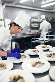 Plating up culinary art. a chef plating food for a meal service in a professional kitchen.