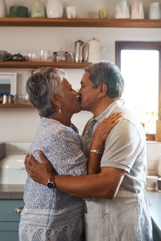 Nothing is more beautiful than eternal love. a mature couple kissing in the kitchen.