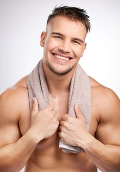 Cant forget a towel. a young man holding a towel against a grey background.