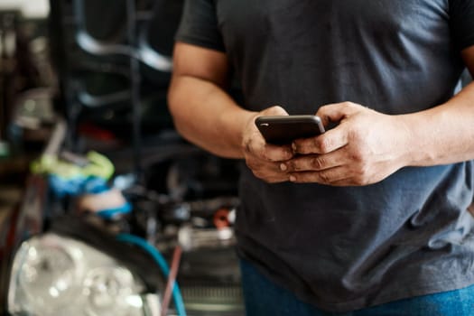 Call your favourite mechanic to do the job for you. a mechanic using his cellphone while working in an auto repair shop.