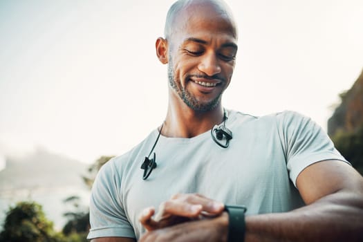 Discipline is the bridge between goals and accomplishment. a man using his watch to track his pulse while out for a workout.