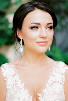 Portrait of a bride in a white lace dress with embroidery