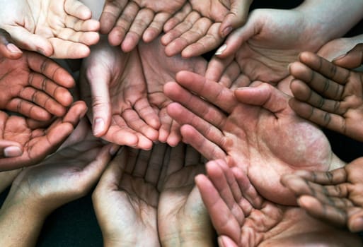 We seek your assistance. a group of hands held cupped out together.