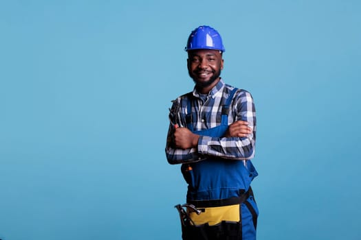 Confident builder with arms crossed holding wrench
