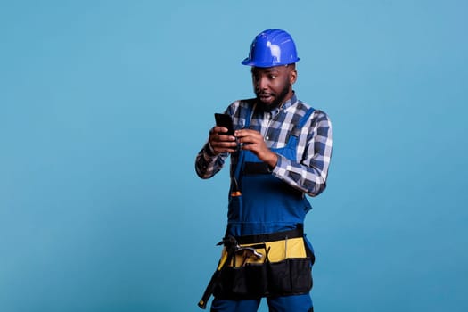 African american builder looking at cell phone