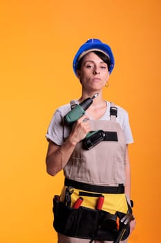 Female industrial builder holding power drill gun