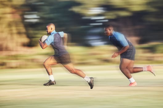 Mixed race rugby player running away from an opponent while attempting to score a try during a rugby match outside on a field. Hispanic male athlete making a play to try and win the game for his team