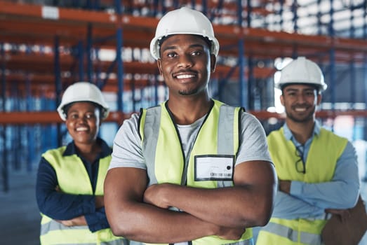 Leave the tough work to us. a group of contractors standing in the warehouse together with their arms folded.