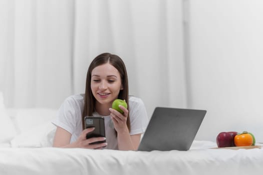Portrait of Good Healthy woman eating green apple and resting in bed at bedroom. Lifestyle at home concept.