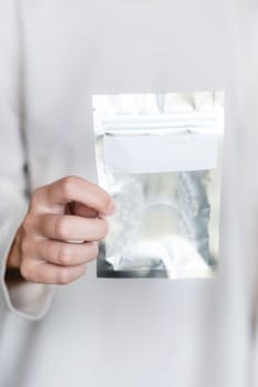 young woman is holding a transparent plastic bag with a zipper in her hands for storing transparent braces or aligners. Close-up of new name packaging