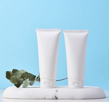 White plastic tub on a marble stand, cosmetic container, advertising and branding of products