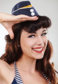 Ready when you are...Smiling nautical pin up girl saluting while isolated on white.