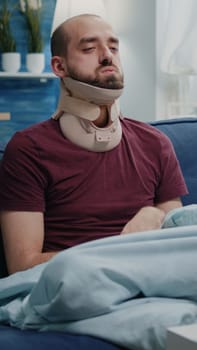 Injured man wearing cervical neck collar against muscle pain
