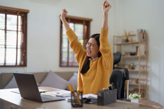 Young happy woman using laptop and celebrating victory and success, have good news, job celebrating achievement