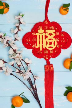 Flat lay Chinese new year tangerine oranges and plum blossoms on wooden table top.
